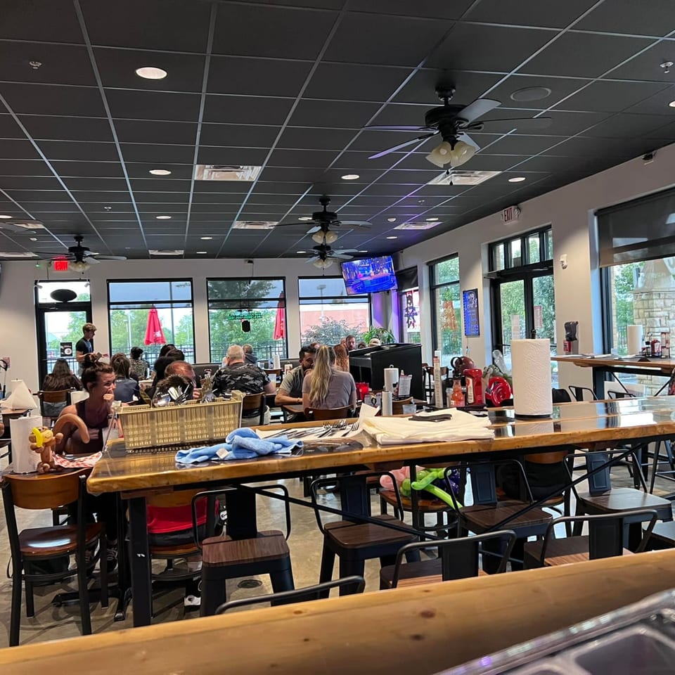 Diners seated at tables and a long communal bar in the bustling Seafood Palace restaurant.